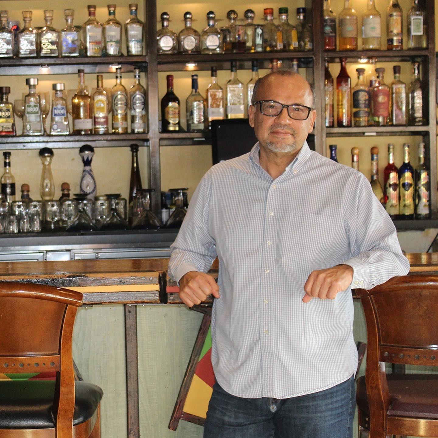 Owner Baldo Cisneros standing at the bar in front of the tequila collection