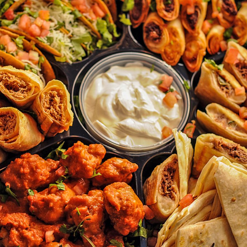 Overhead view of the Party Platter tray with wings, tacos, taquitos, quesadillas and sour cream